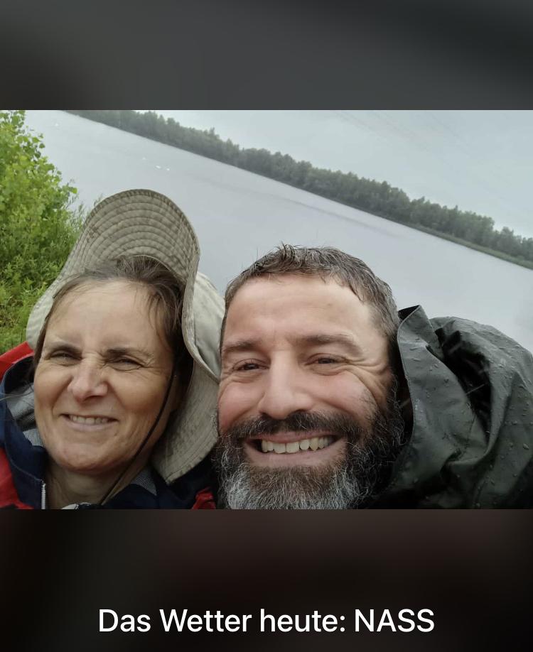 Bild von der Pilgerwanderung. Eine Frau und ein Mann an einem See